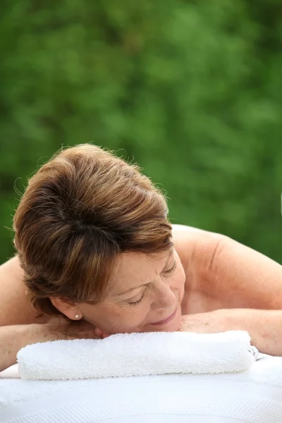 Mulher sênior na cama de massagem — Fotografia de Stock
