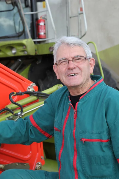 Farmer standing by harvester — Stock Photo, Image