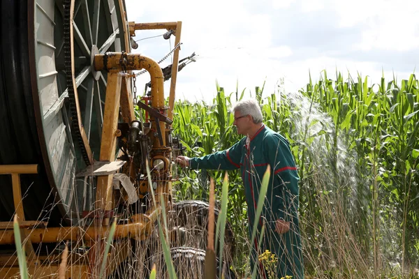 Agricultor que controla máquinas de irrigação — Fotografia de Stock