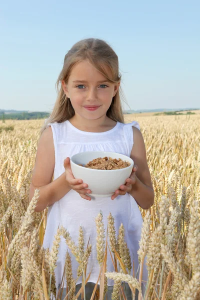 Маленька дівчинка тримає миску з зернових — стокове фото