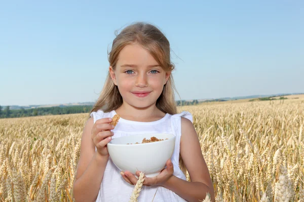 Little girl holding bowl of cereals