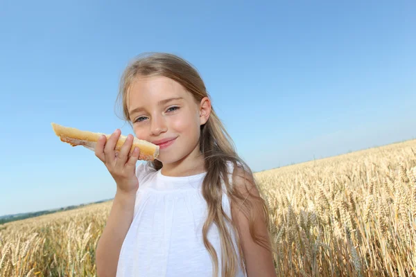 Little girl holding slide of french bread — Stock Photo, Image