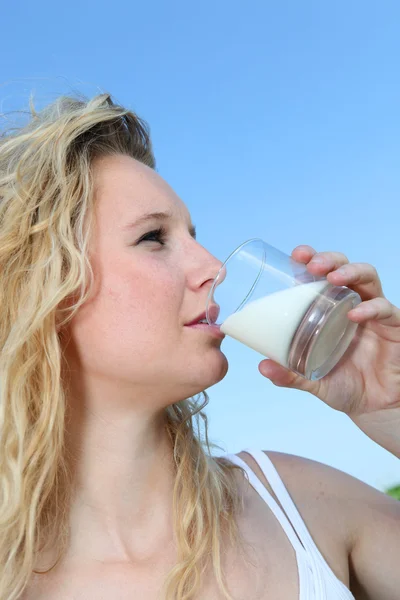 Jovem mulher beber leite — Fotografia de Stock
