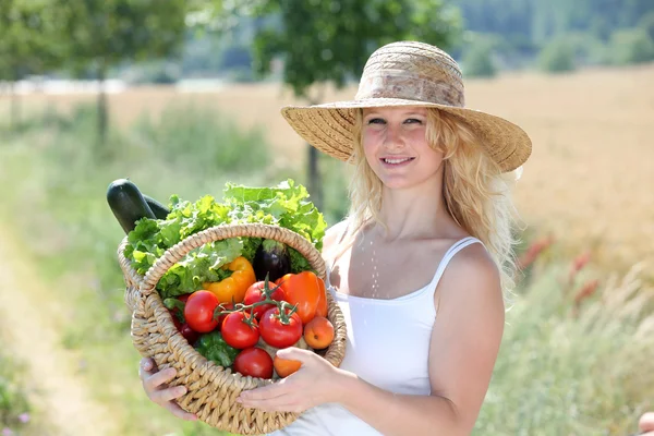Beautiful woman with basket of vegetables — Stock Photo, Image
