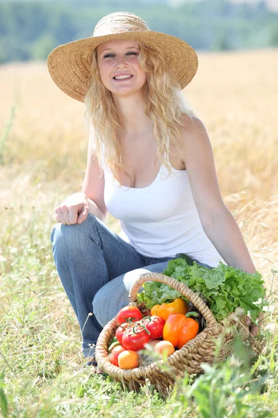 Vacker kvinna med korg med grönsaker — Stockfoto