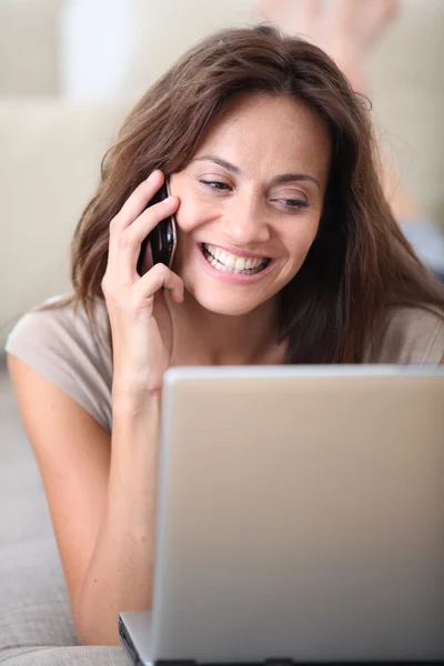 Vrouw met laptopcomputer en telefoon — Stok fotoğraf