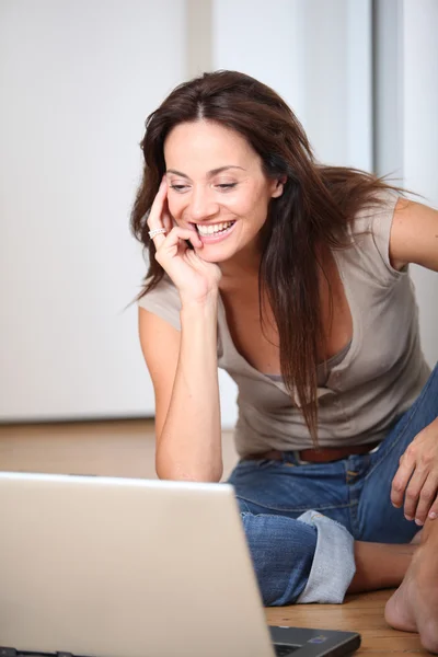 Kvinna som sitter med bärbar dator — Stockfoto