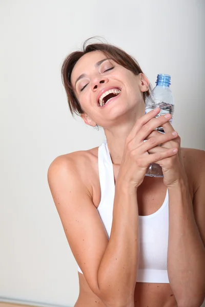 Mujer bebiendo agua después de hacer ejercicio — Foto de Stock