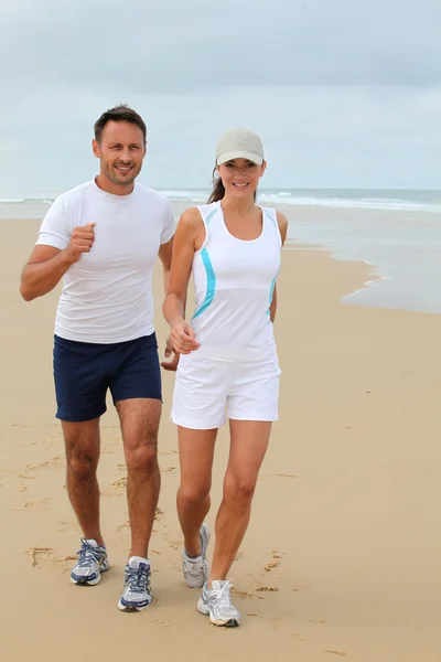 Pár jogging homokos strandon — Stock Fotó