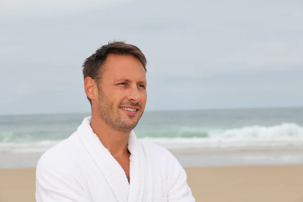 Man with bathrobe on the beach — Stock Photo, Image