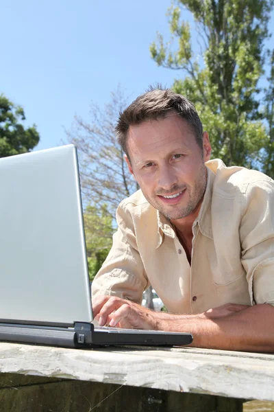 Mann mit Laptop auf Ponton — Stockfoto