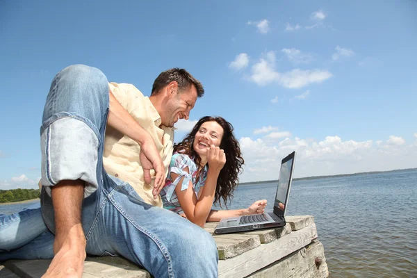 Par med laptop på en ponton — Stockfoto