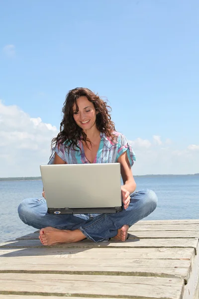 Жінка з ноутбуком на понтоні — стокове фото