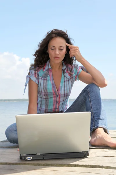 Kvinna med laptop på en ponton — Stockfoto
