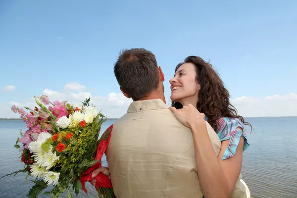Loving couple with bunch of flowers — Stock Photo, Image