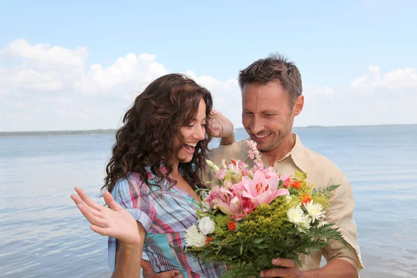 Loving couple with bunch of flowers — Stock Photo, Image