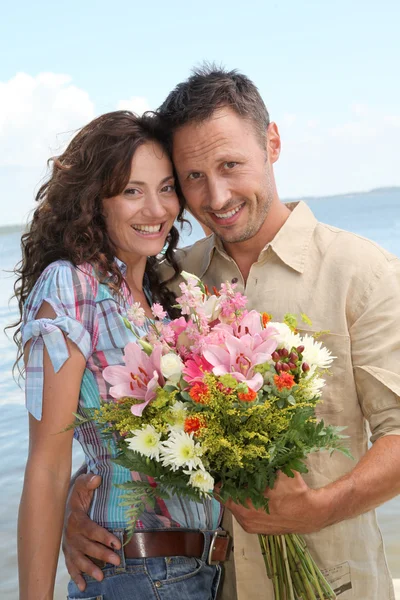 Verliefde paar met bos van bloemen — Stockfoto
