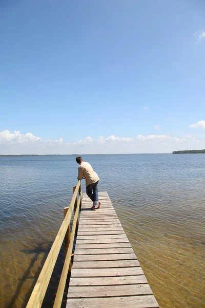 Man på en ponton vid en sjö — Stockfoto