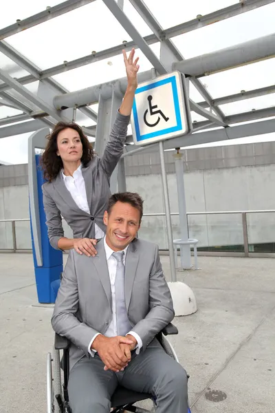 Donna d'affari con uomo in sedia a rotelle — Foto Stock