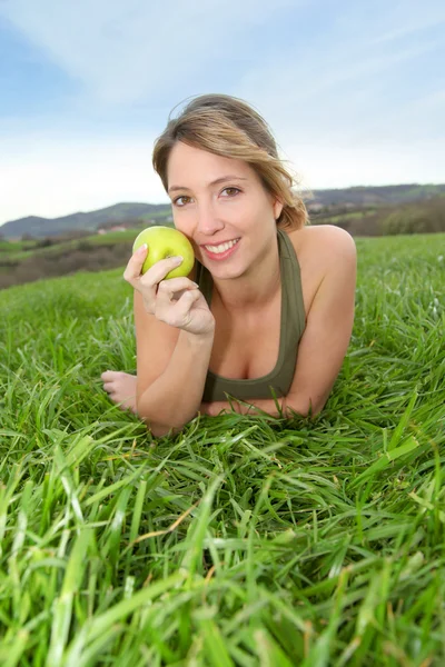 Женщина ест зеленое яблоко — стоковое фото