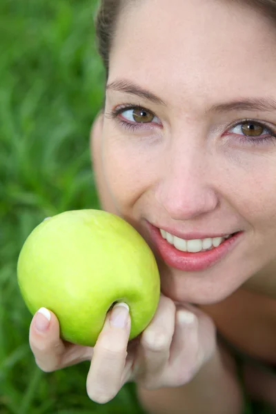 Vrouw eet een groene appel — Stockfoto