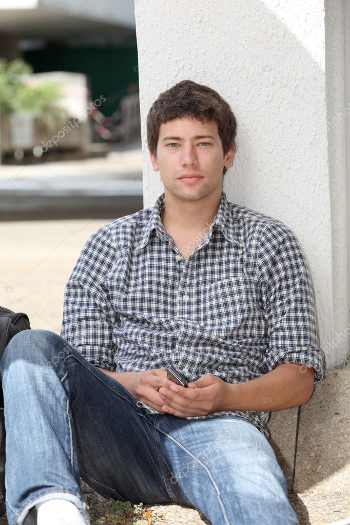 Young man sitting on the ground