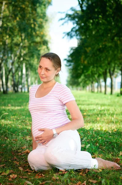 Hermosa mujer embarazada relajándose en el parque — Foto de Stock