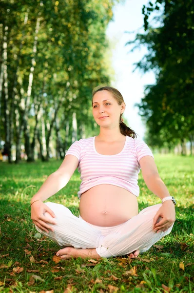 Mulher grávida bonita relaxante no parque — Fotografia de Stock