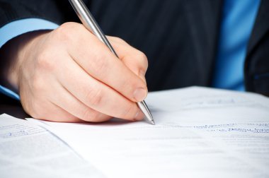 Businessman with pen signing contract clipart