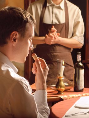 A young man sniffing the cork clipart