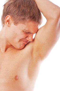 Closeup of young man sniffing his armpit isolated on white background clipart