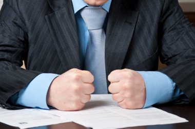 Closeup of businessman with clenched fists clipart