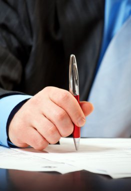 Businessman with pen signing contract clipart