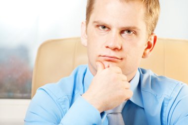 Portrait of a young thoughtful businessman in doubt about something clipart