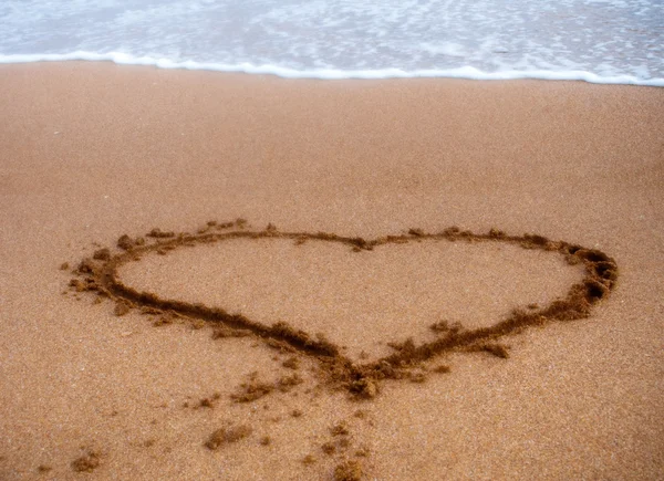这是一张在沙上画一颗心的照片 — 图库照片