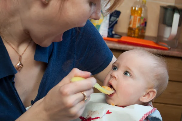 Um bebê pequeno bonito alimentado por sua mãe — Fotografia de Stock
