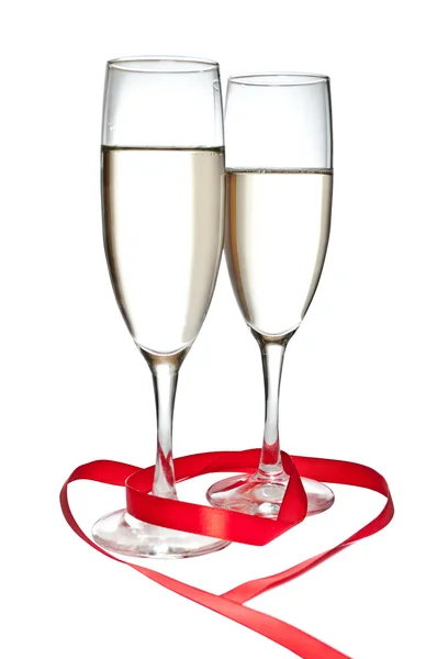 Copos com champanhe e fita vermelha isolada sobre fundo branco — Fotografia de Stock