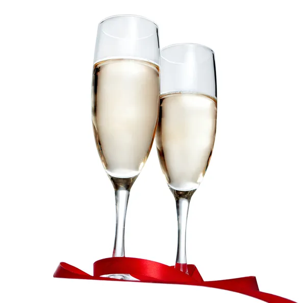 Brýle s šampaňským a červená stuha izolovaných na bílém pozadí — Stock fotografie