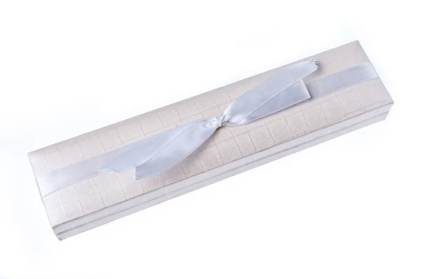 Белая подарочная коробка с белой текстильной лентой и бантом — стоковое фото