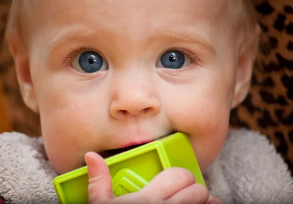 Bebê segurando um bloco verde enfrentando câmera — Fotografia de Stock
