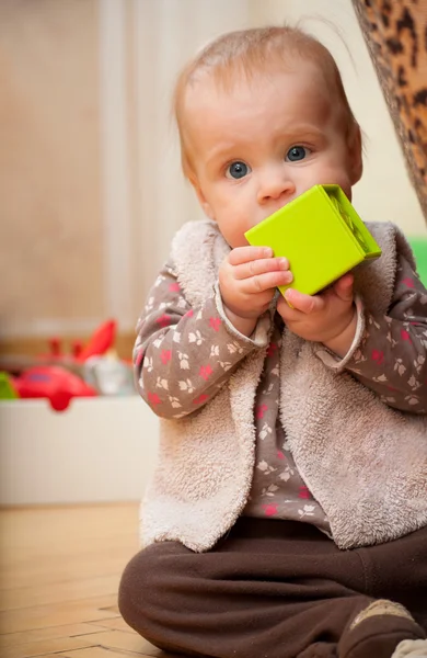 Ребенок держит зеленый блок лицом к камере — стоковое фото