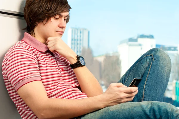 Portréja egy trendi fiatal srác gépelés egy üzenet-ra mozgatható telefon — Stock Fotó