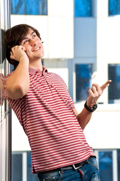 Улыбающийся молодой человек, говорящий по телефону — стоковое фото