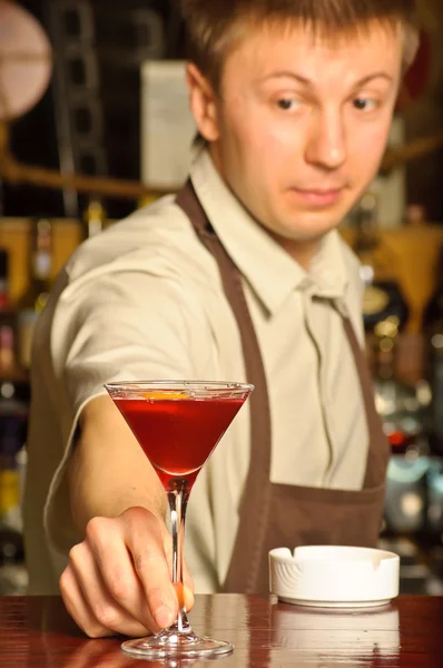 Ein Barmann hält das Glas mit Cocktail — Stockfoto