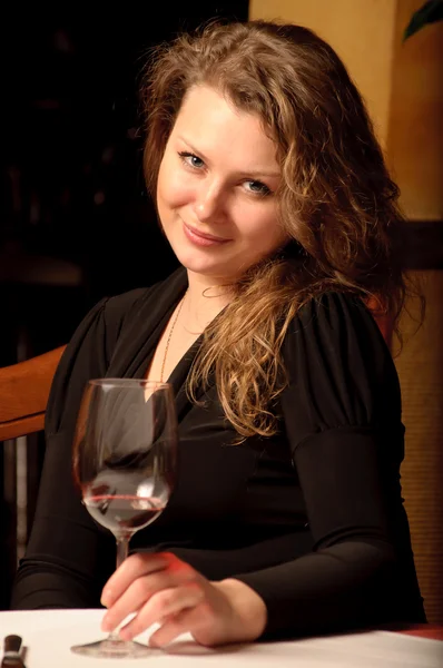 Piękna młoda kobieta siedzi w restauracji — Zdjęcie stockowe