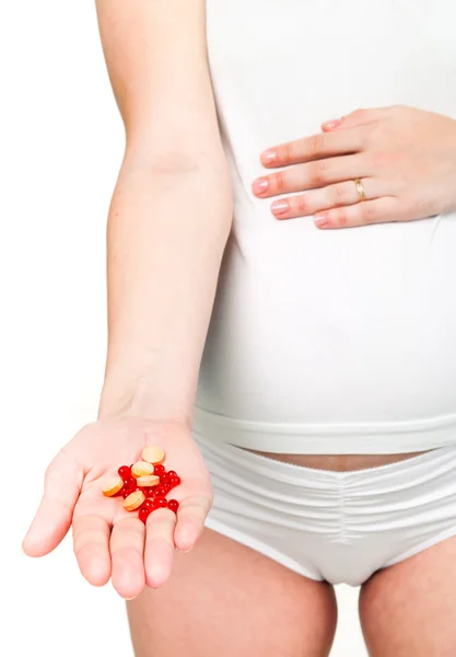 Femme enceinte tenant des pilules — Photo