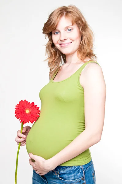 Młoda kobieta w ciąży, trzymając ręce na jej brzuch — Zdjęcie stockowe