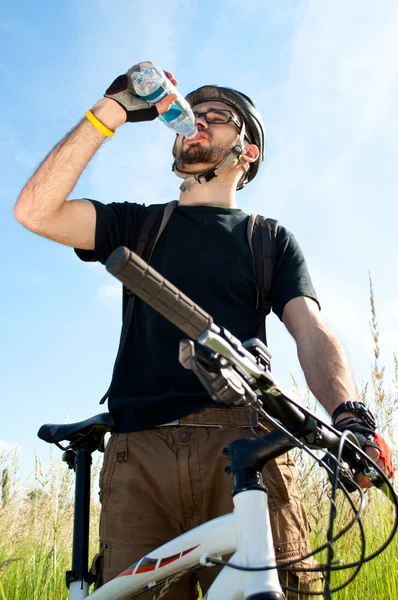 Nahaufnahme eines jungen Radfahrers, der Wasser trinkt — Stockfoto