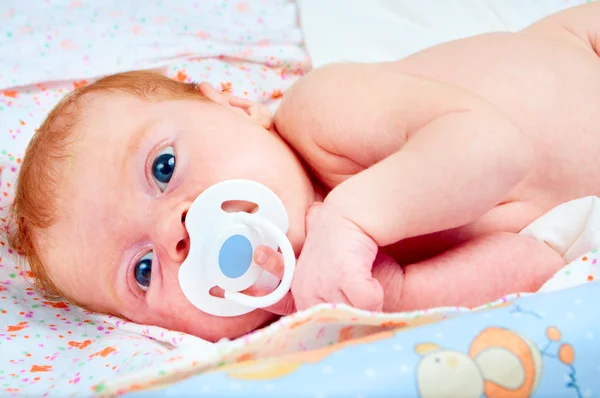 Новорожденный ребенок с успокаивающим — стоковое фото