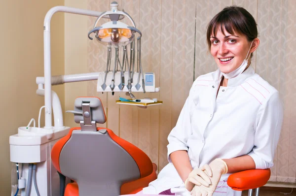 Młody dentysta w jej biurze patrząc na widza — Zdjęcie stockowe